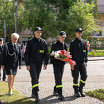 grupa strażanków niosąca kwiaty
